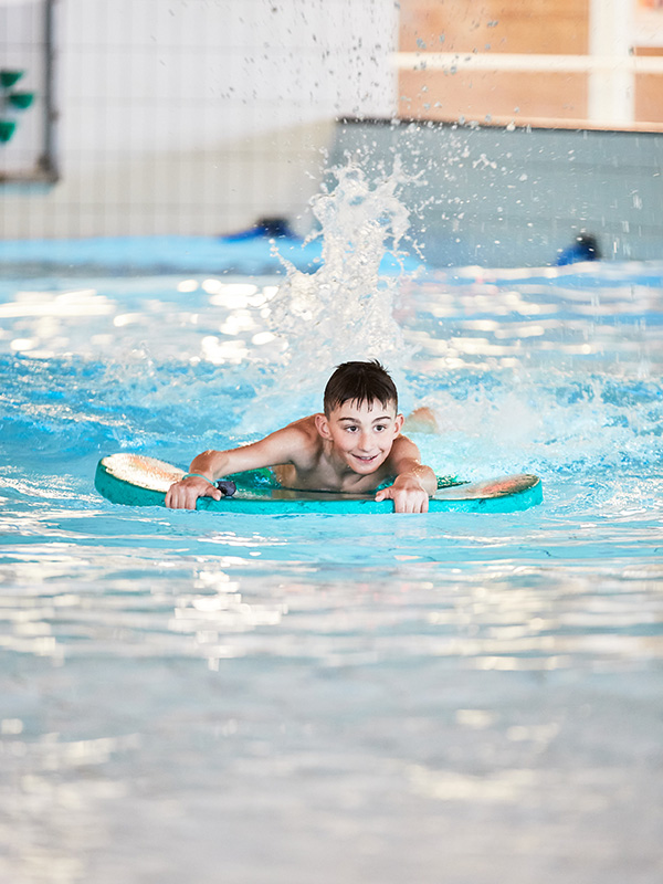 Kille på flytleksak i pool
