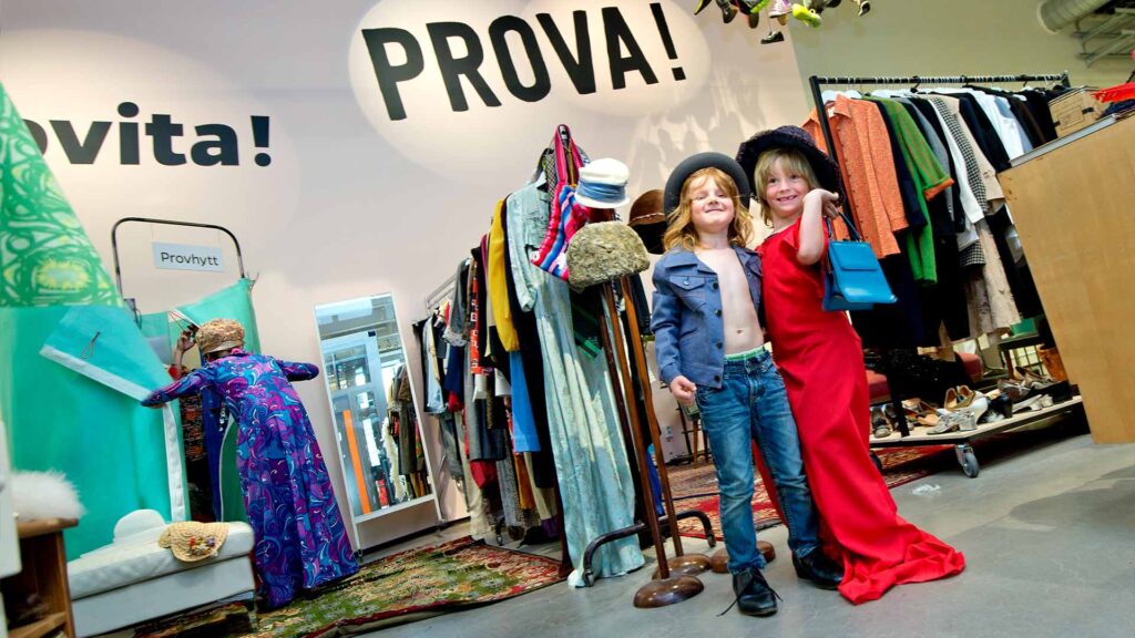 Två barn poserar utklädda i vuxenkläder