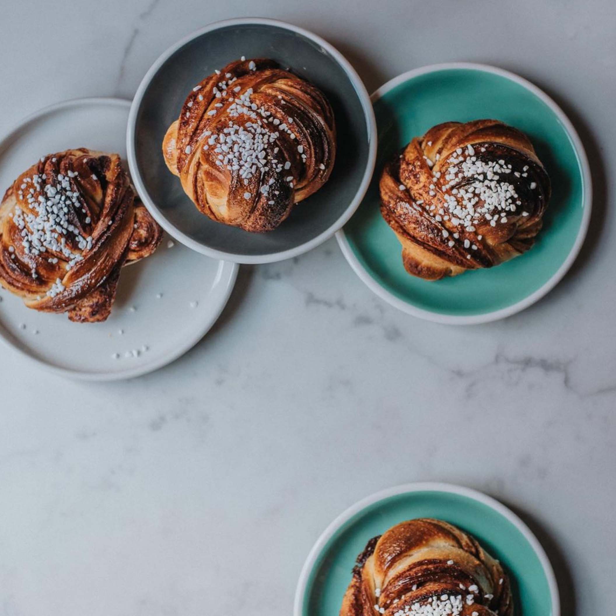 Fyra kanelbullar på varsitt fat.
