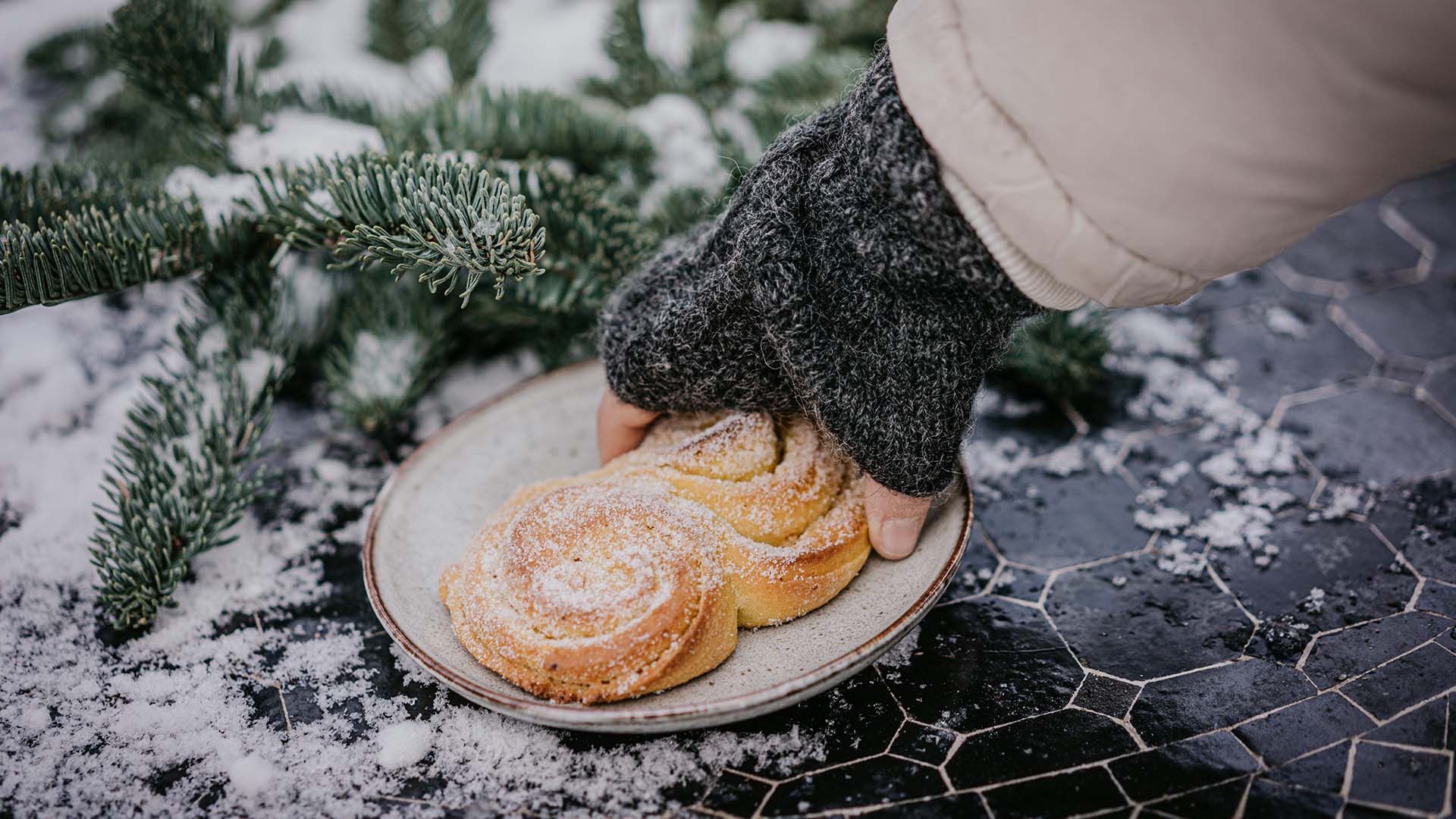 En hand plockar upp en sockrad lussekatt