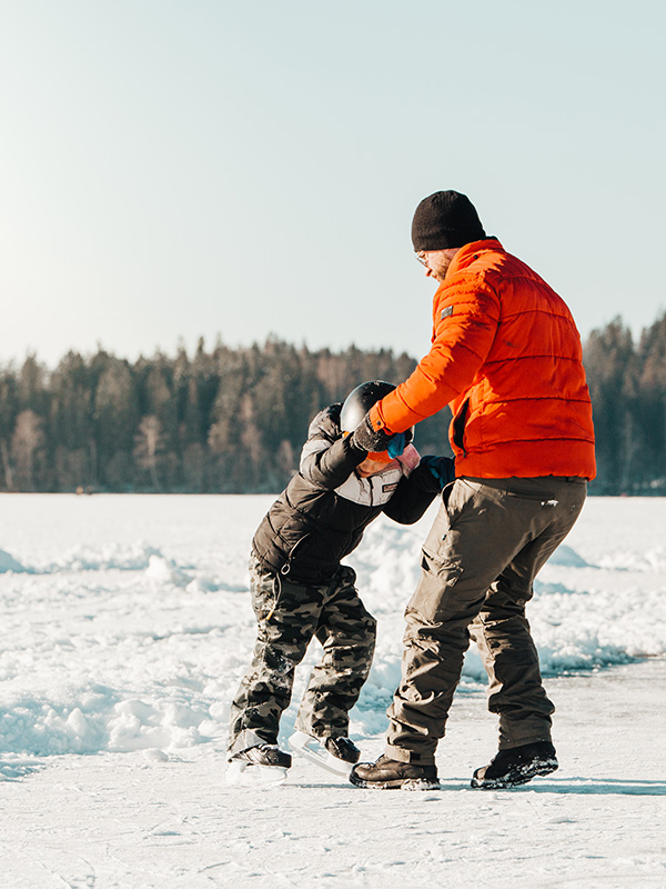 En pappa och hans son åker skridskor.