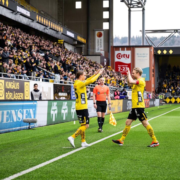 Två spelare gör high five på planen.