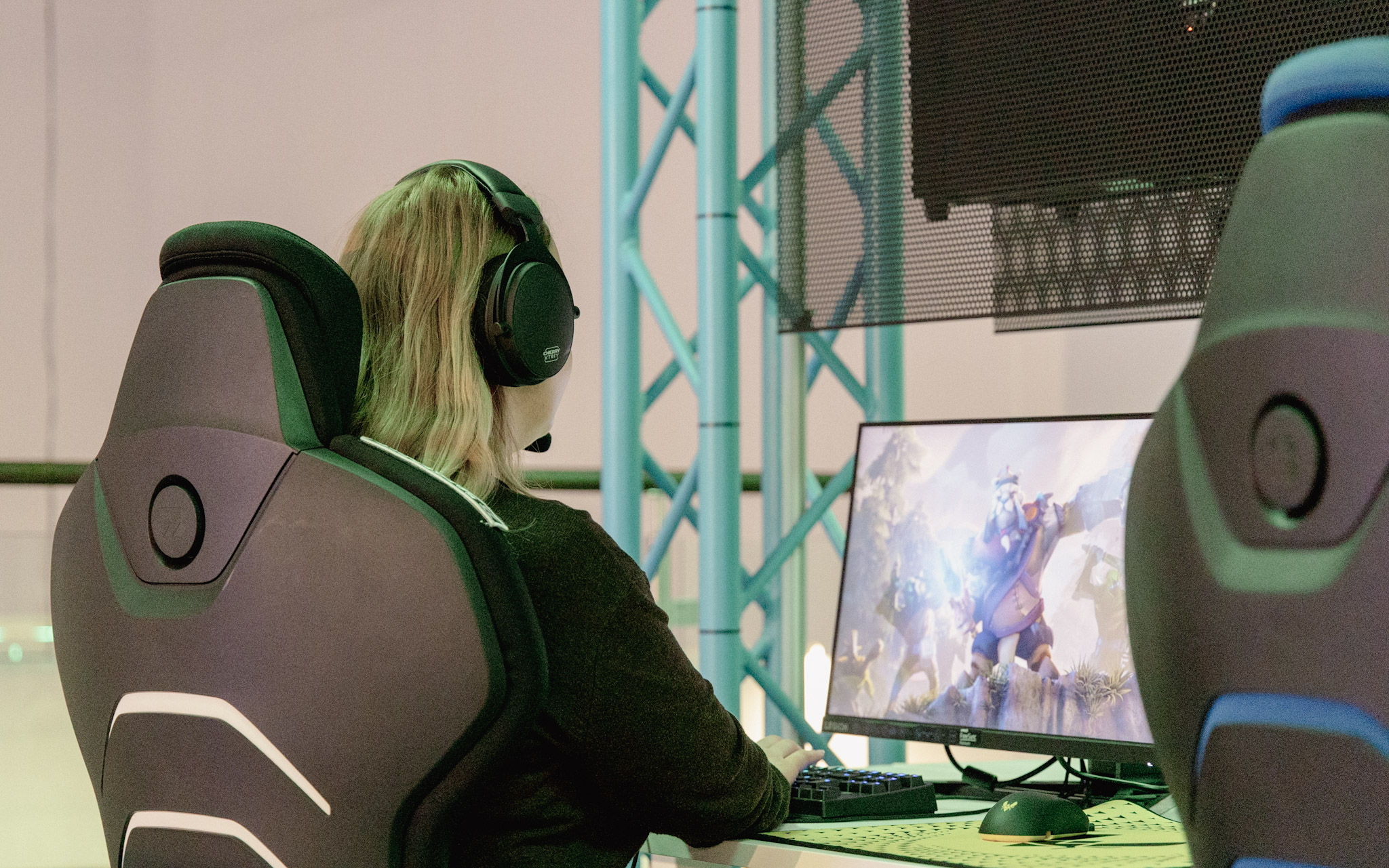 En tjej sitter framför en dator och gejmar..