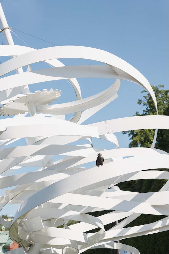 En fågel sitter på en skulptur.