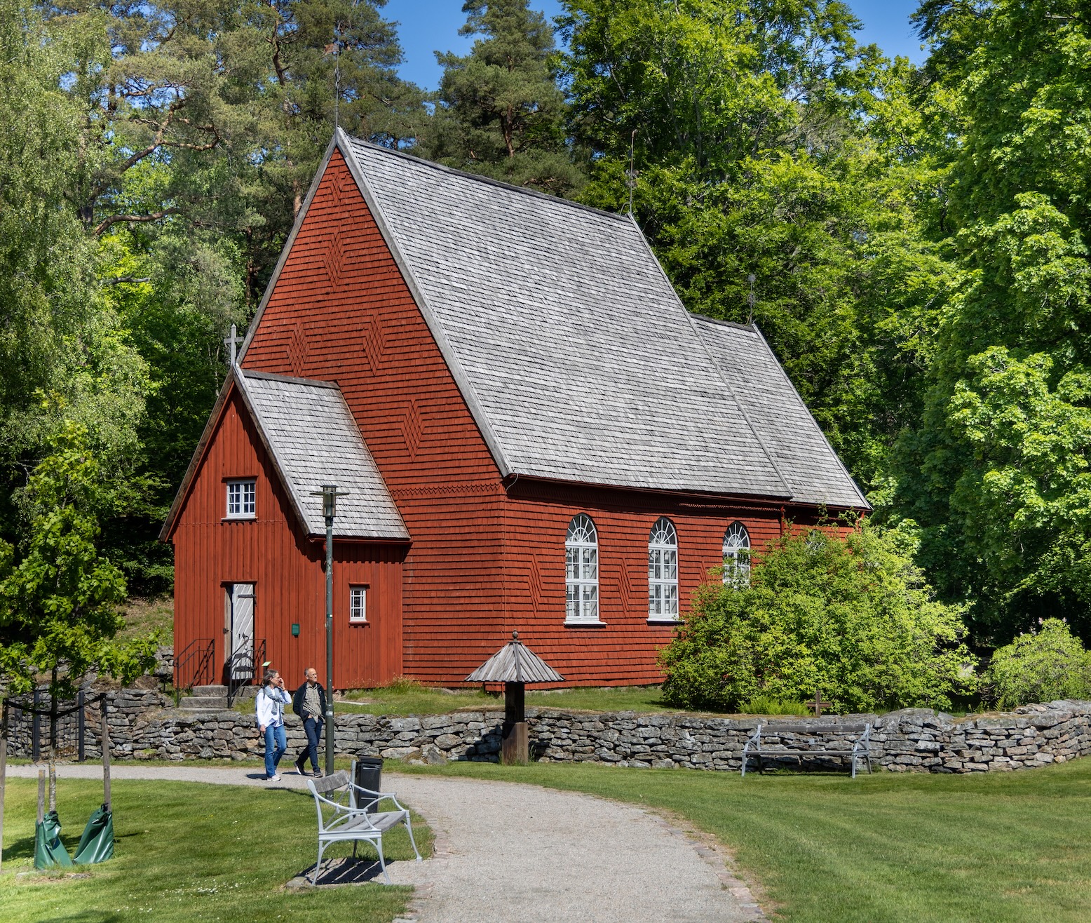 En röd kyrka med en gångväg som leder till den.