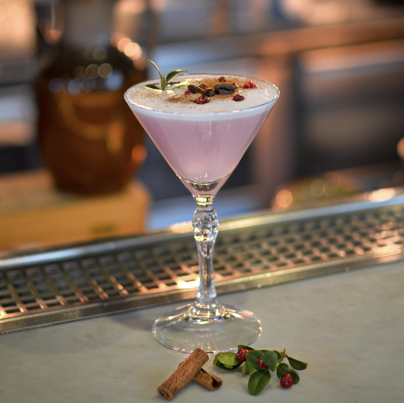 En rosa drink i ett cocktailglas.